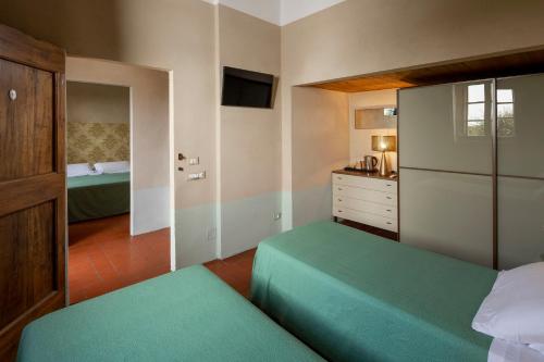 a small bedroom with two beds and a dresser at Hotel Le Capanne in Arezzo
