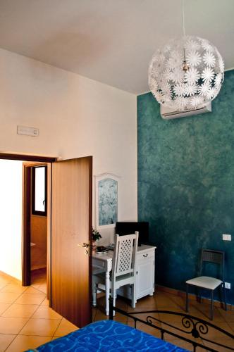 a room with a desk with a computer and a chandelier at B&B Libertà Marsala in Marsala