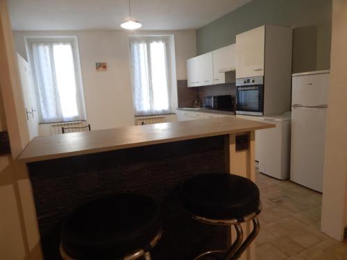 a kitchen with two bar stools and a counter top at 25 F Mistral 1 er G in Coursan