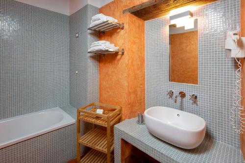 a bathroom with a sink and a tub and a bath tub at Hotel Le Capanne in Arezzo