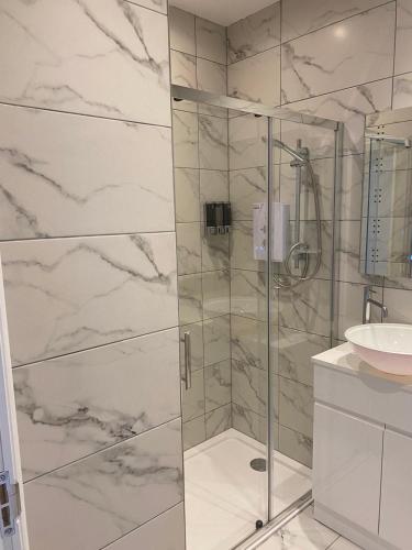 a bathroom with a glass shower and a sink at Belmont Apartment 2 in Aberystwyth