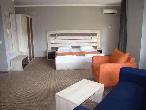a hotel room with a bed and a chair at Blue Orange Beach Resort in Sozopol
