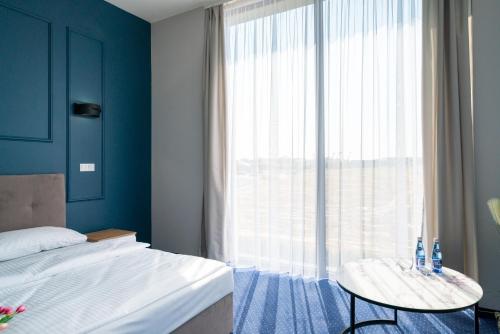 a bedroom with a bed and a table and a large window at Aquila Hotel in Zator