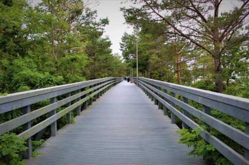 a bridge in a park with a person walking on it at Prima Playa in Międzyzdroje