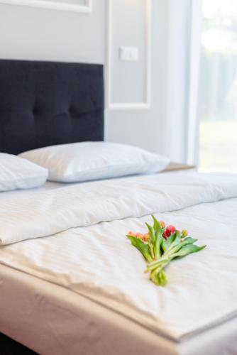 a bouquet of flowers sitting on a bed at Aquila Hotel in Zator