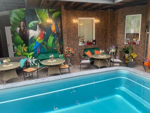 una piscina con mesas, sillas y una pintura en Hotel Nika, en Adler