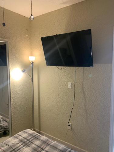 een flatscreen-tv aan de muur van een slaapkamer bij bedroom private in Miami