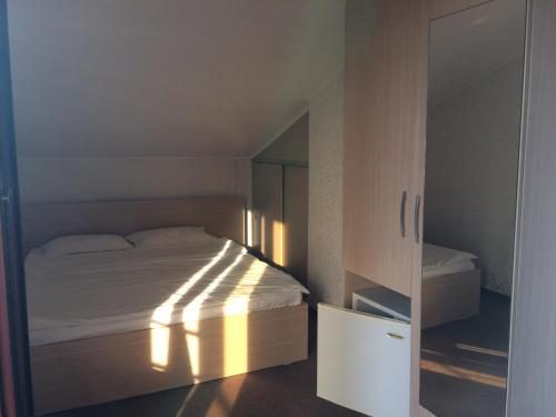 a small bedroom with a bed and a cabinet at Vila Patricia in Eforie Nord