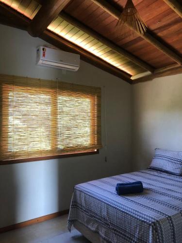 a bedroom with a bed with a blue blanket and a window at Cond ReservaTaipu, apart 202 in Barra Grande
