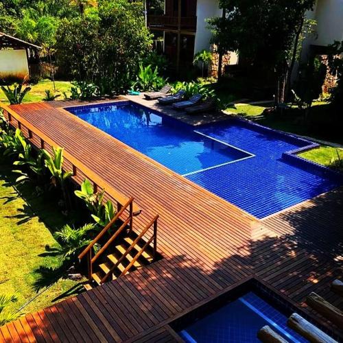 a swimming pool in a yard with a wooden deck at Cond ReservaTaipu, apart 202 in Barra Grande