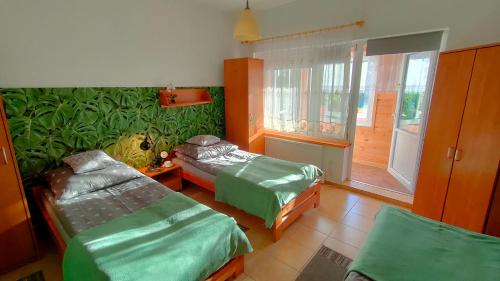 a room with two beds and a window at Rodzinne Siedlisko in Biskupiec