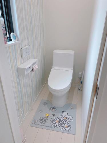 een kleine badkamer met een toilet en een bloemkleed bij Watatsumi no yado - Vacation STAY 44120v in Iki