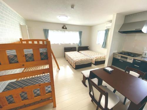 une chambre avec une cuisine et une chambre avec une table et un lit dans l'établissement Watatsumi no yado - Vacation STAY 44120v, à Iki