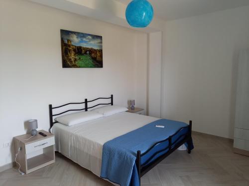 1 dormitorio con 1 cama y una pintura en la pared en B&B SAINT LOUIS, en Presicce