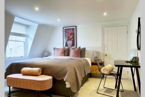 a bedroom with a bed and a chair and a table at Ideally located 2 bedroom luxury apartment in Bath