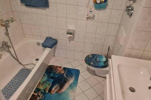 a bathroom with a picture of a dolphin on the bath tub at Ferienwohnung Laura in Bad Reichenhall