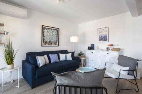 a living room with a blue couch and a table at Superb 3 stars flat w balcony - Saint-Jean-de-Luz - Welkeys in Saint-Jean-de-Luz