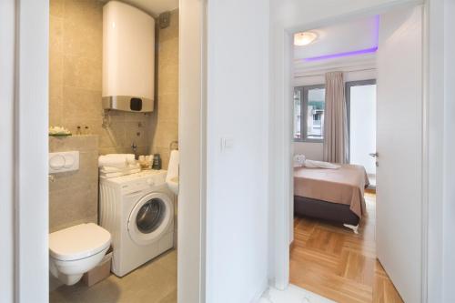 ein Bad mit einem WC, einem Waschbecken und einer Waschmaschine in der Unterkunft City center lux apartment in Budva