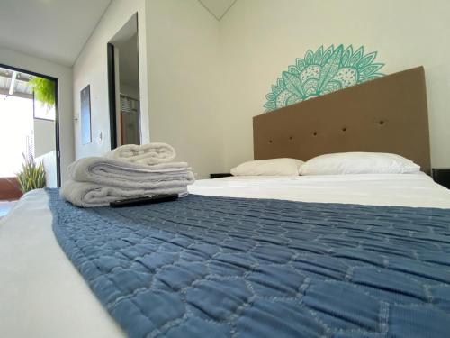 a bedroom with a large bed with towels on it at CasaBlanca ApartaEstudios in Girardot