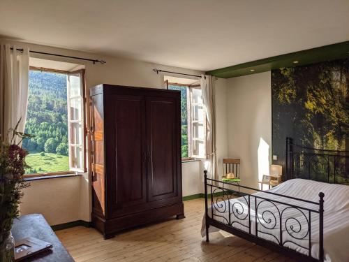 a bedroom with a bed and a large window at La Caminada Vielha in Montaillou