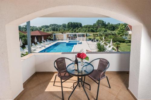 a balcony with a table and chairs and a pool at Christopher's apartments in Ulcinj