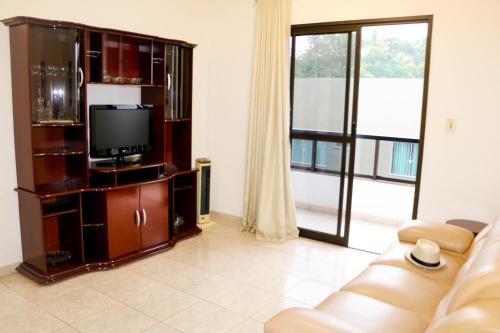 sala de estar con TV y sofá en Ótimo apartamento na Praia dos Castelhanos com Wi-Fi en Anchieta