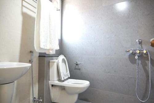 a bathroom with a toilet and a sink at Srivar Hotels in Guruvāyūr