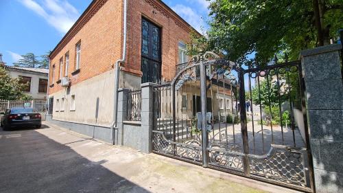 an iron gate in front of a brick building at Guest House Panda in Kutaisi