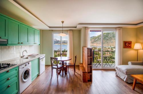 a kitchen with green cabinets and a living room with a table at Defne Residence Selimiye in Marmaris