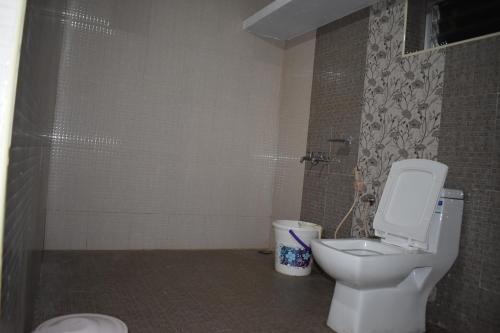 a bathroom with a toilet and a shower at Hotel Sri Balaji in Ooty