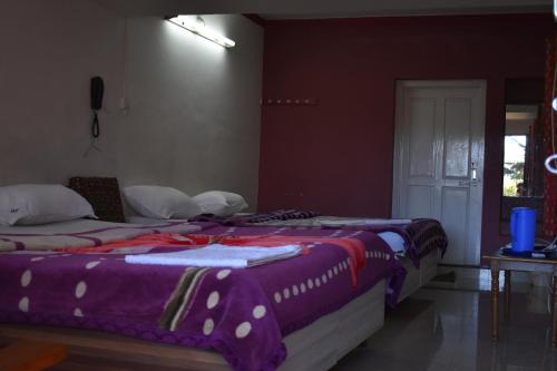 two beds sitting next to each other in a bedroom at Hotel Sri Balaji in Ooty