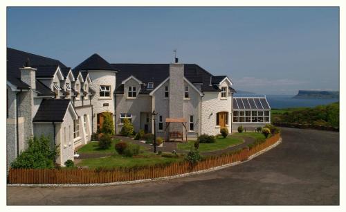 a large house on the side of a road at Crockatinney guest house in Ballintoy