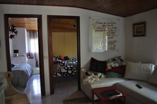 a living room with a couch and a bedroom at Ollar do Cido in Seoane