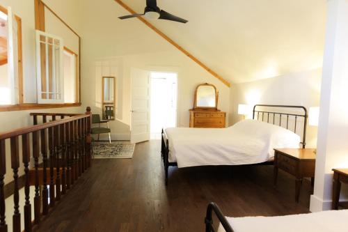 a bedroom with two beds and a staircase at Jackson's Falls Country Inn in Milford