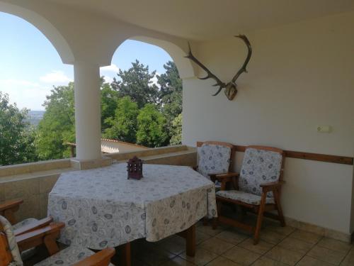 una mesa y sillas en un balcón con vistas en Bottyahát guesthouse en Rezi