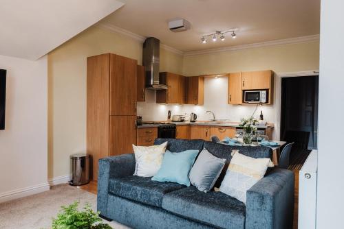 a living room with a couch and a kitchen at Seaforth House Apartment in Elgin