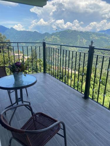 a table and chairs on a balcony with a view at Vista Zacatlan Hotel in Zacatlán
