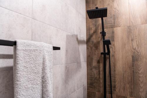 a shower with a white towel hanging on a rack at Guest House Rossy in Trigrad