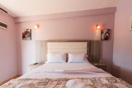 a bedroom with a large bed with two pillows at Christopher's apartments in Ulcinj