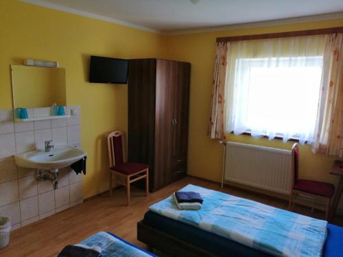 a bedroom with a bed and a sink and a window at Haus Staubmann Nähe Red Bull Ring Spielberg in Rattenberg