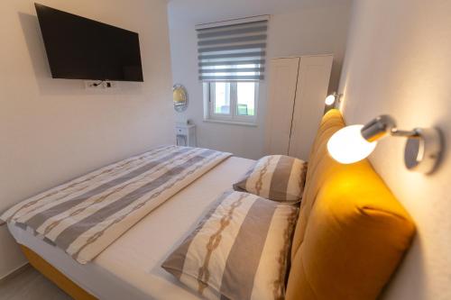 a bedroom with a bed with a television on the wall at Apartments Luka in Senj