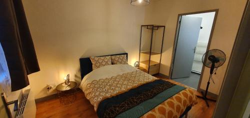 a bedroom with a bed with a lamp and a door at Les balcons de Dieppe - appartement 1ER étage - certifié 3 étoiles au cœur de la rue piétonne in Dieppe