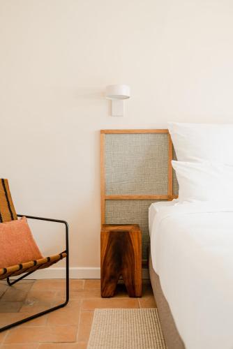 a bedroom with a bed and a chair and a table at Aethos Saragano in Saragano
