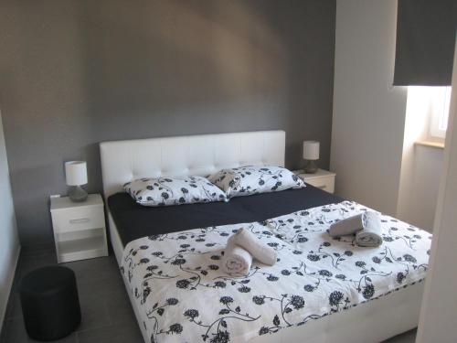 1 dormitorio con 1 cama con edredón blanco y negro en Apartment "MANNA en Korčula