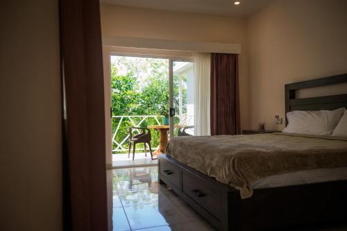 1 dormitorio con 1 cama y puerta corredera de cristal en Casa Coco de Mer 2, en Tamarindo