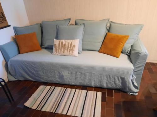een blauwe bank met kussens bovenop een kamer bij Appartamento tra Lago e natura in Sesto Calende