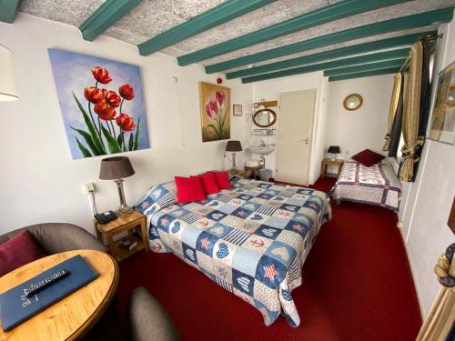 a bedroom with a bed and a table at Hotel & Restaurant De Fortuna in Edam