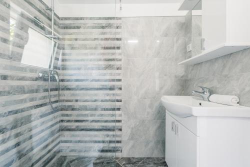 a white bathroom with a sink and a shower at Christopher's apartments in Ulcinj