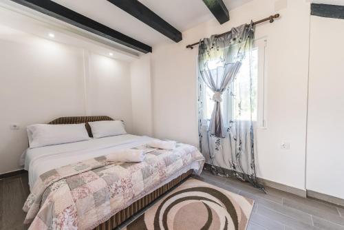 a bedroom with a bed and a window at Christopher's apartments in Ulcinj