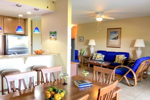 a kitchen and a living room with a table and a couch at Poipu Sands 214 in Kipu